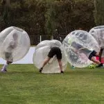 Groupe jouant au football à bulles